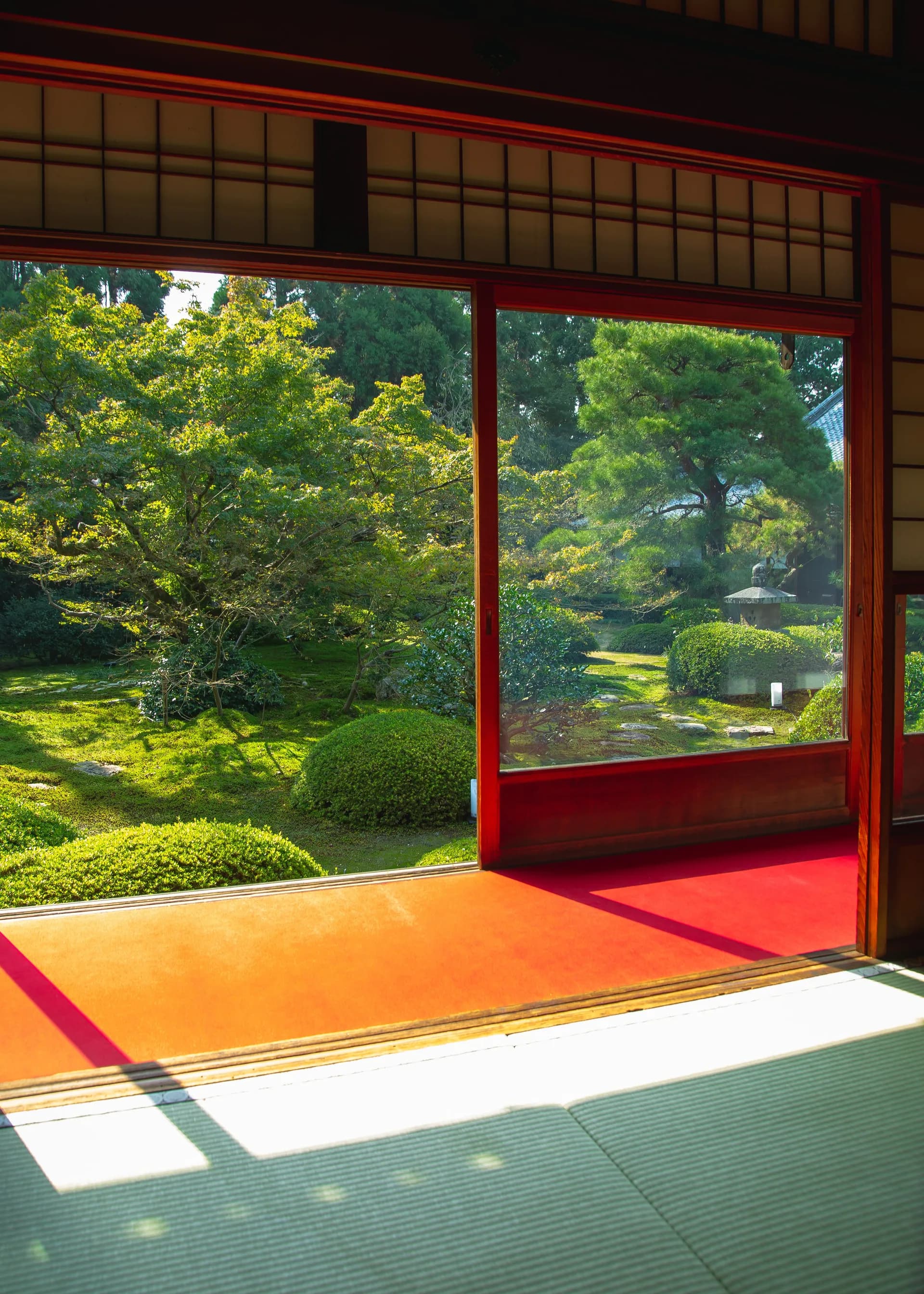 BookNoFees Primjer slike: Soba u japanskom stilu opremljena je tatami prostirkama. Kroz veliki otvor vidi se zeleni vrt.