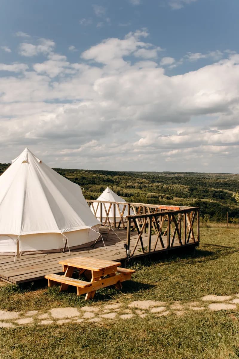 Primjer slike BookNoFees: glamping šatori postavljeni na drvene platforme u otvorenom krajoliku