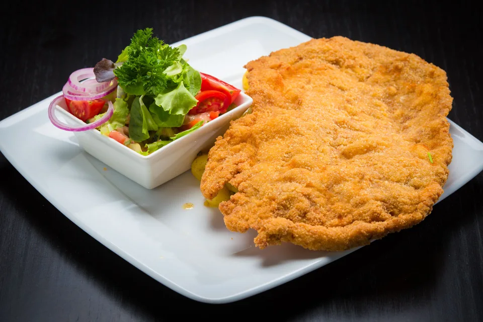 BookNoFees: Primjer fotografije: Panko-panirani šnicl s prilogom salate na bijelom tanjuru