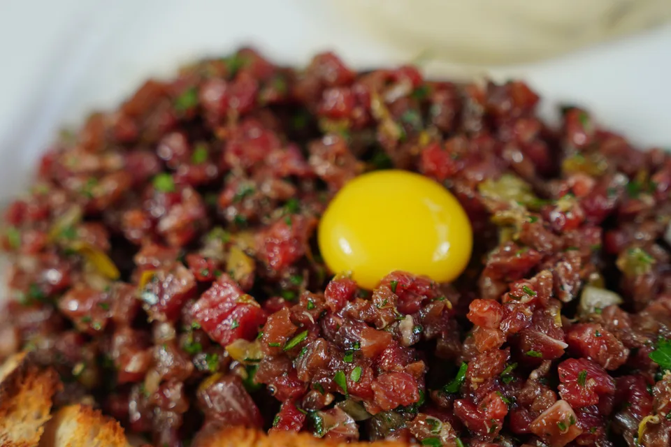 BookNoFees: Primjer fotografije: Steak tartare prekriven žumanjkom i poslužen s tostiranim kruhom
