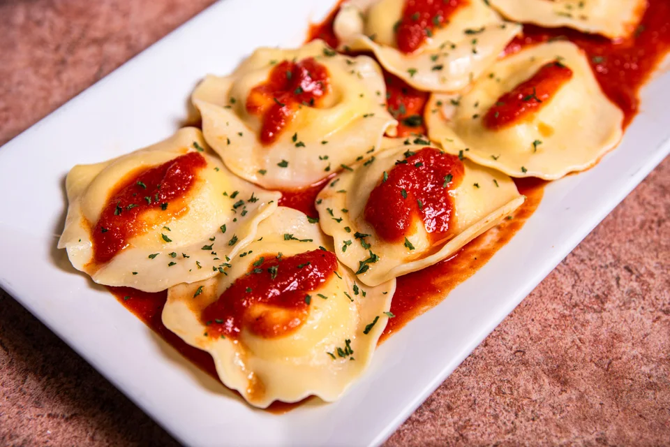 Primjer fotografije: Ravioli preliveni umakom od rajčice i začinskim biljem na bijelom tanjuru